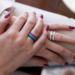 Lady's hands with combination of different E3 Silicone stackers on her fingers, and E3 Silicone stackers stacked with her metal diamond ring